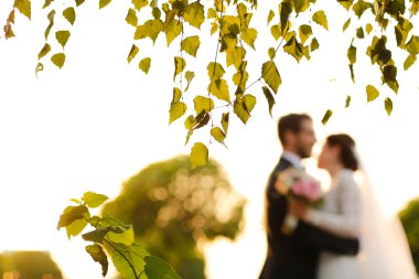 Neşeli gelin ve damat ile açık havada kucaklayan buket