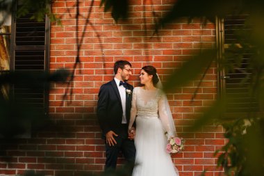 Neşeli gelin ve damat ile açık havada kucaklayan buket