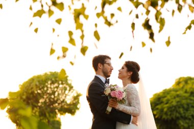 Neşeli gelin ve damat ile açık havada kucaklayan buket