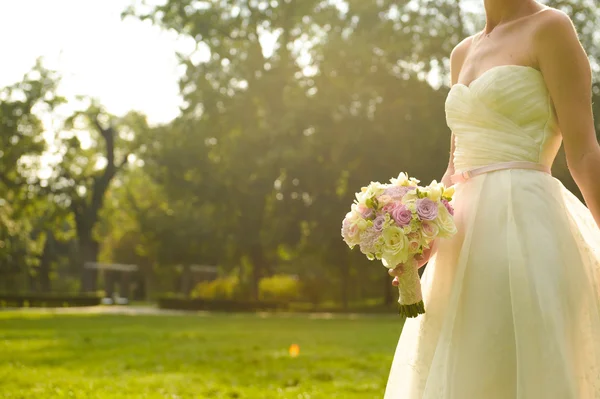 Blijde bruid met boeket poseren buiten — Stockfoto