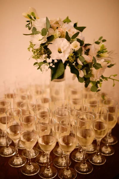 Beau bouquet en vase entouré de verres de champagne — Photo