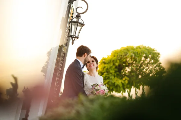 Gioiosa sposa e lo sposo con bouquet che abbraccia all'aperto — Foto Stock