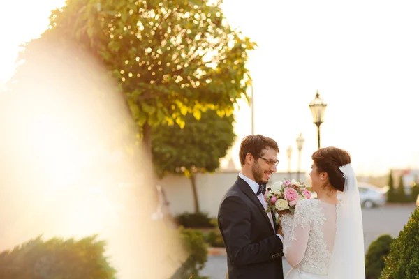 快乐的新娘与新郎同拥抱在户外的花束 — 图库照片
