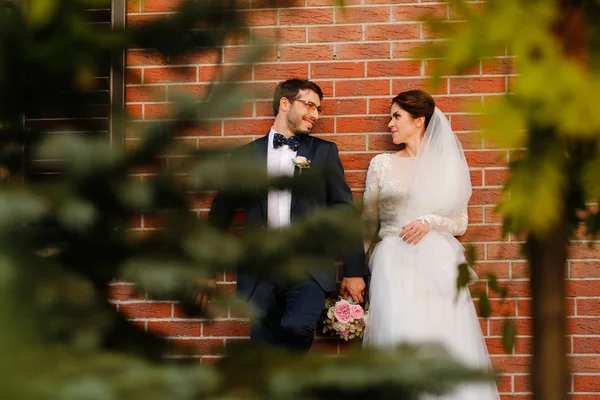 Joyful bruden och brudgummen med bukett embracing utomhus — Stockfoto