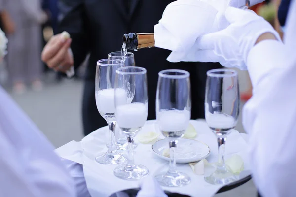 Waiter serving champagne on a tray — Stock Photo, Image