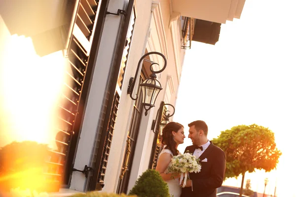 Beautiful bridal couple embracing in sunlight — Stock Photo, Image