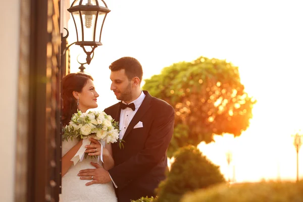 Vackra brudparet embracing i solljus — Stockfoto