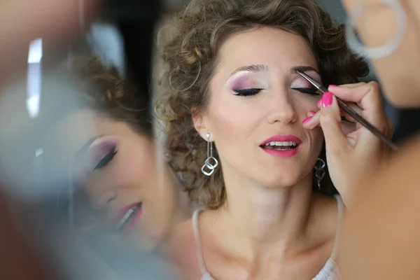 Beautiful bride getting professional makeup — Stock Photo, Image