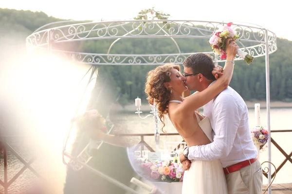 Belo casal nupcial abraçando perto do lago — Fotografia de Stock