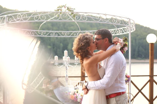 Schönes Brautpaar umarmt sich am See — Stockfoto