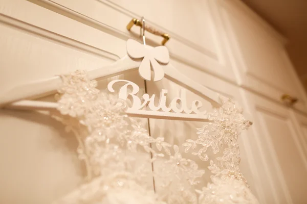 wedding dress hanged on a white wardrobe