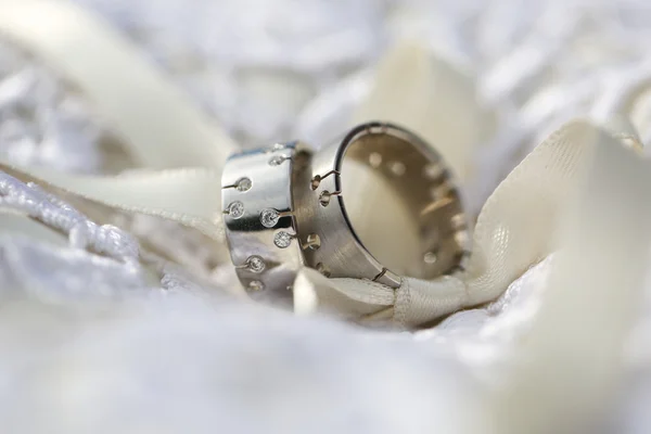 Два серебряных обручальных кольца на белой подушке — стоковое фото