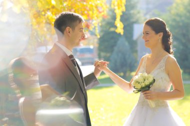  Gelin ve damat parkta poz veriyorlar.