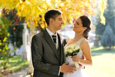  Gelin ve damat parkta poz veriyorlar.