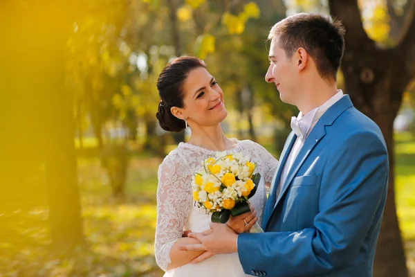 Ženich a nevěsta pózuje v parku — Stock fotografie