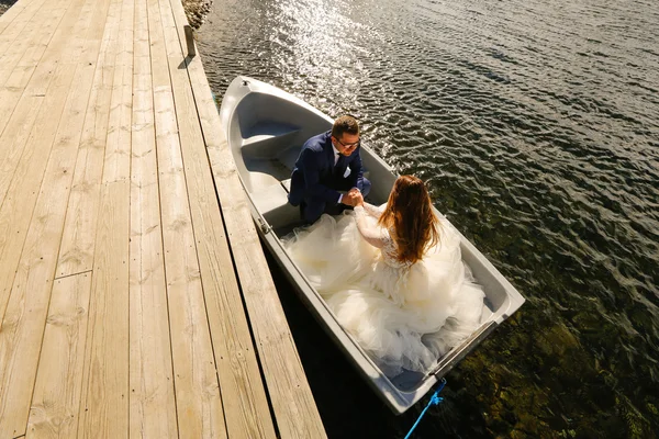 Groom and bride sitting in a boat — Stock Photo, Image