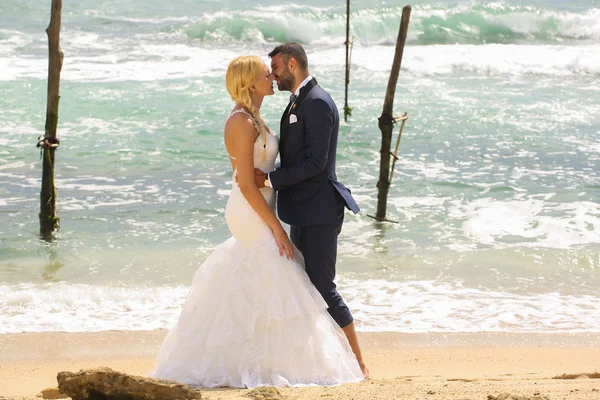 Sposo e sposa in posa sulla spiaggia — Foto Stock