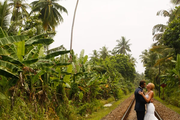 Bruid en bruidegom lopen op spoor — Stockfoto