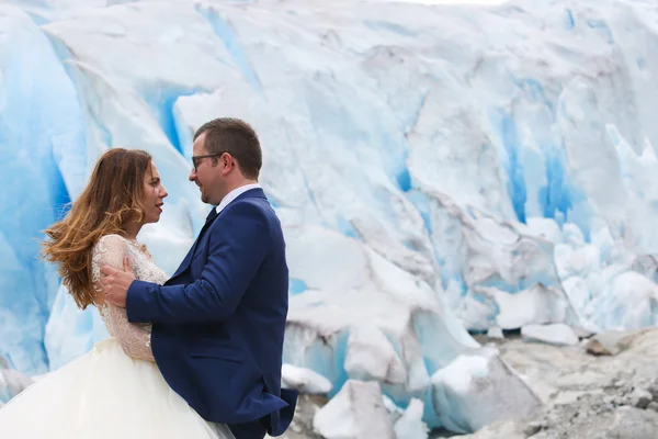 Невеста и жених позируют возле ледника — стоковое фото