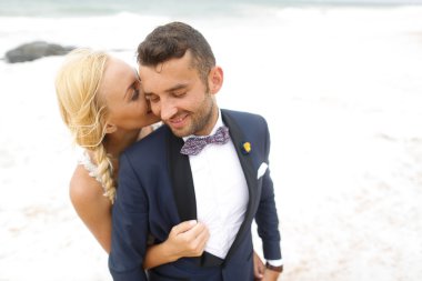 Gelin ve damat sahilde poz veriyorlar.