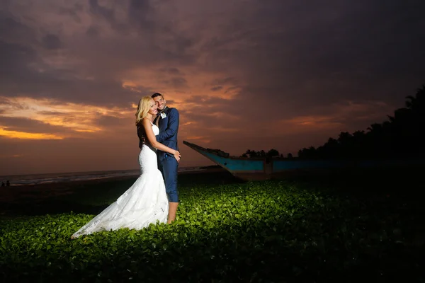 Mariée et marié posant au coucher du soleil — Photo