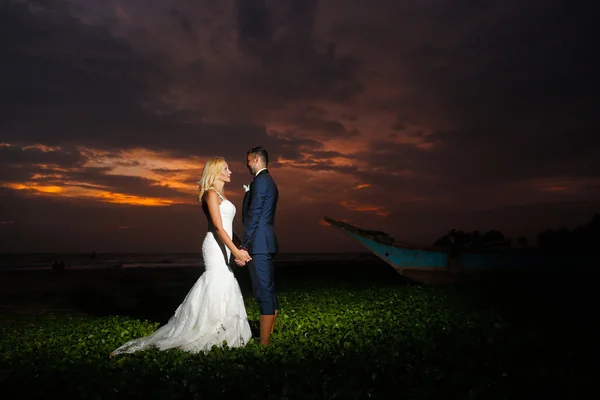 Mariée et marié posant au coucher du soleil — Photo