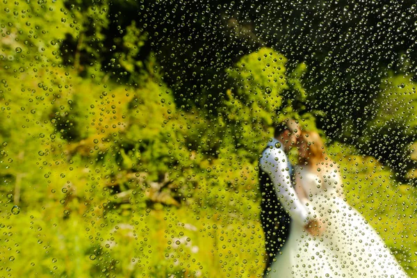 Nevěsta a ženich představovat venkovní koryta mokré čočka — Stock fotografie