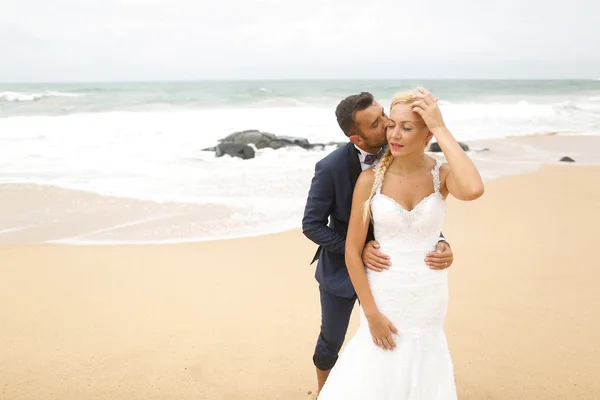 Novia y novio posando en la playa — Foto de Stock