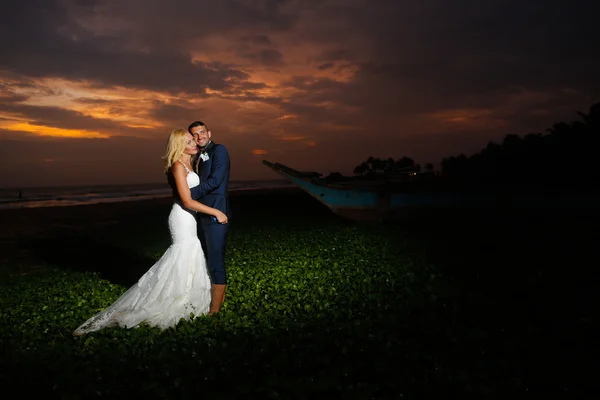 Mariée et marié posant au coucher du soleil — Photo