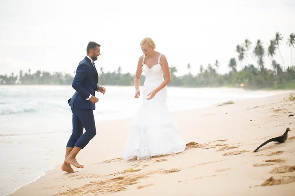 Mariée et marié jouer sur la plage — Photo