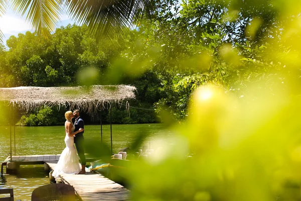 Nevěsta a ženich pózuje na tropický ostrov — Stock fotografie