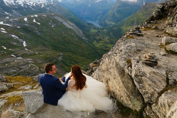新娘和新郎坐在悬崖上 — 图库照片