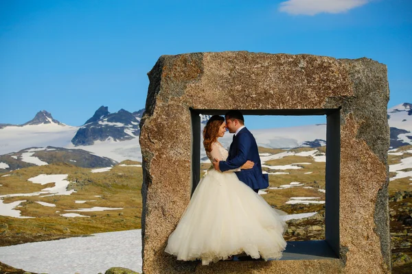 Gelin ve damat kayalar yapılan büyük bir kare pencerede poz — Stok fotoğraf