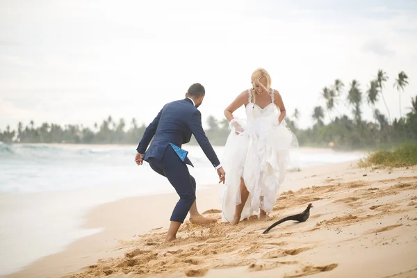 Νύφη και γαμπρός παίζοντας στην παραλία — Φωτογραφία Αρχείου