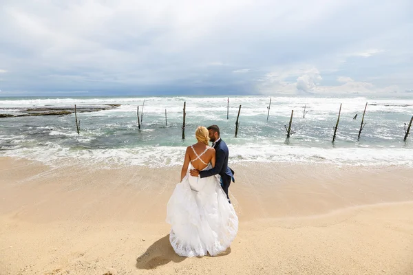 Mariée et marié posant sur la plage — Photo