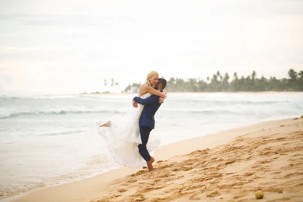 Sposo e sposa che giocano sulla spiaggia — Foto Stock