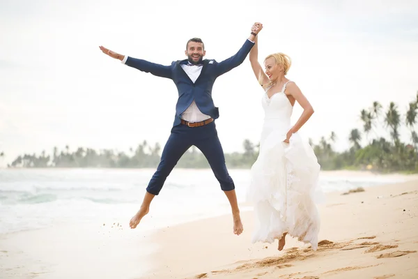 Braut und Bräutigam spielen am Strand — Stockfoto