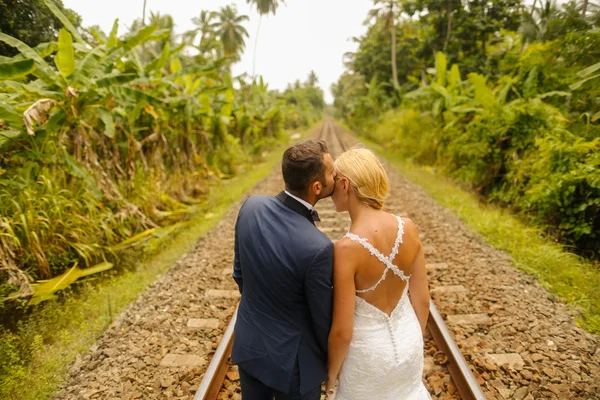Braut und Bräutigam zu Fuß auf der Bahn — Stockfoto