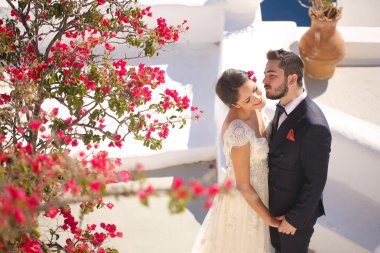 Gelin ve damat bir evin Santorini'de çatıda oturan