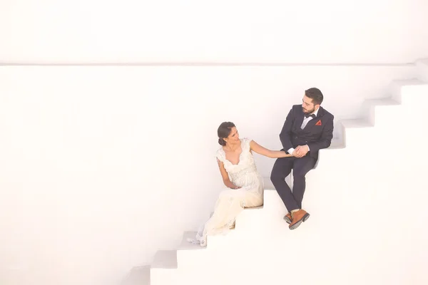 Novia y novio sentado en una escalera blanca —  Fotos de Stock