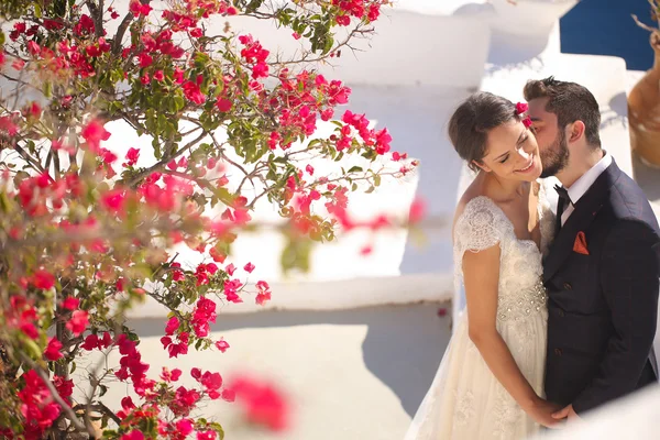 Bruid en bruidegom zittend op het dak van een huis in Santorini — Stockfoto