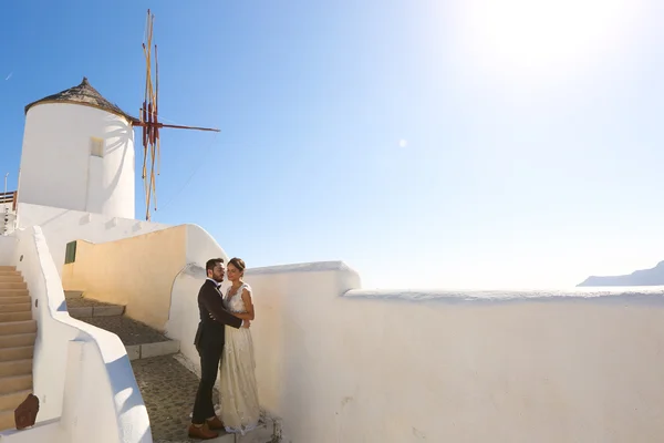Nevěsta a ženich pózuje u bílé větrný mlýn — Stock fotografie