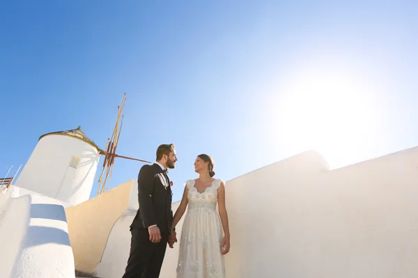 Noiva e noivo posando perto de um moinho de vento branco — Fotografia de Stock