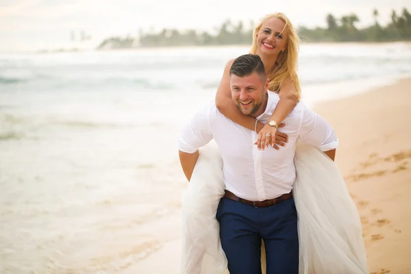 Bruid en bruidegom plezier op het strand — Stockfoto
