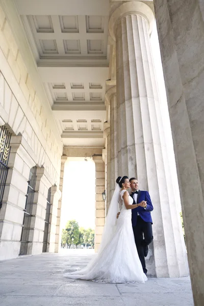 Krásný svatební pár objímat poblíž sloupců — Stock fotografie