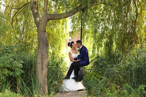 Mooie bruidspaar plezier op een schommel — Stockfoto