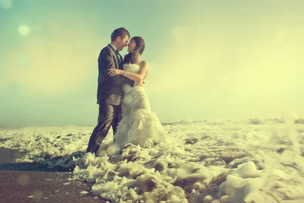 Groom and bride hugging in the sea — Stock Photo, Image