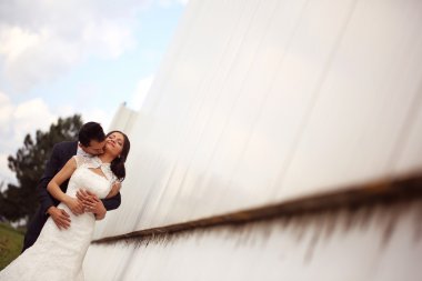 Gelin ve damat dışarıda poz veriyorlar.