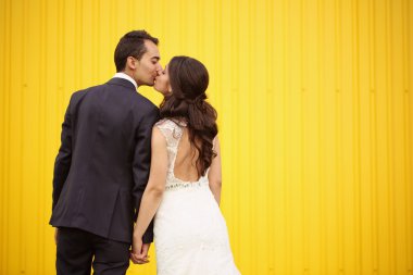 Gelin ve damat sarı duvara karşı karşıya