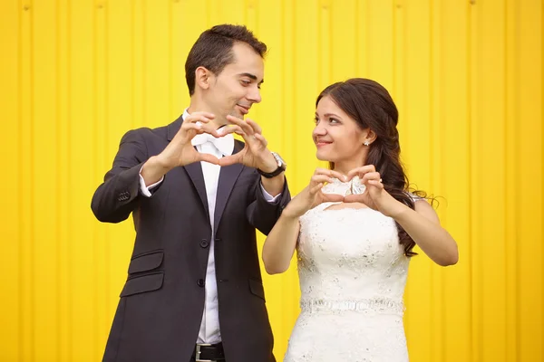Bruden och brudgummen att göra hjärtat tecken — Stockfoto